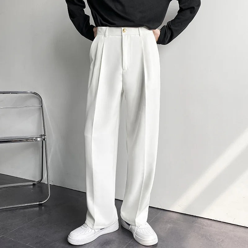 Men's Arno Trousers in white linen, tailored fit, shown on a model with hands on hips, highlighting the waist and pleat details.