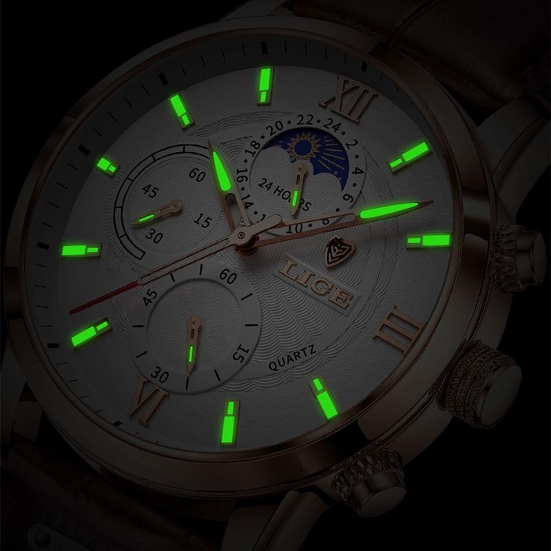 A close-up view of the Aurelius Timepiece men's watch with a gold-tone case and white dial, showcasing its luminous hands and hour markers glowing brightly in the dark.