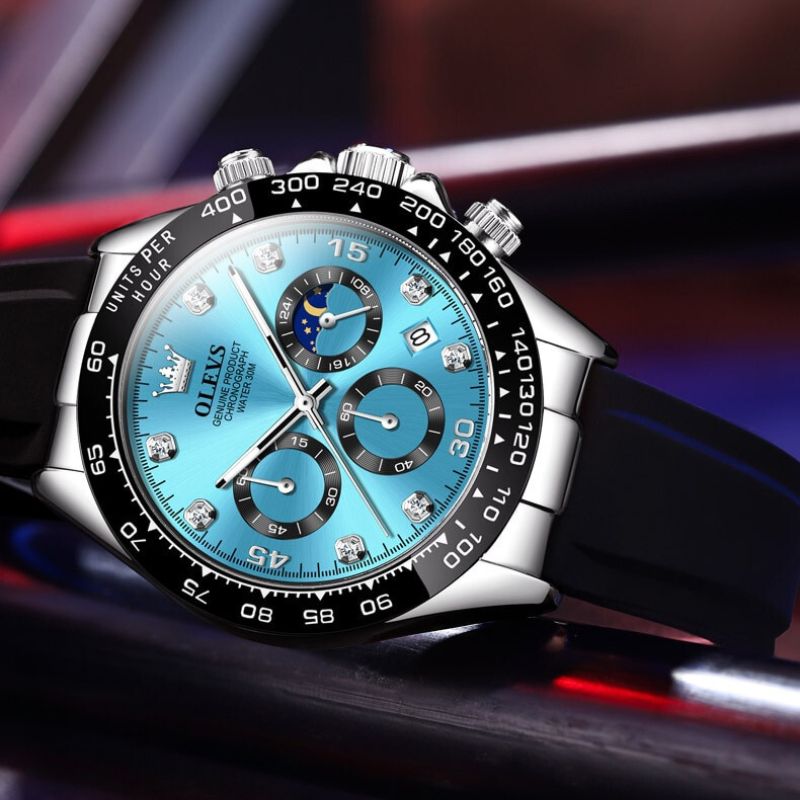 Men's Elysium Timepiece watch with a blue dial, silver-tone case, black silicone strap, quartz movement, luminous hands, and date display. Features three subdials and diamond-like hour markers.