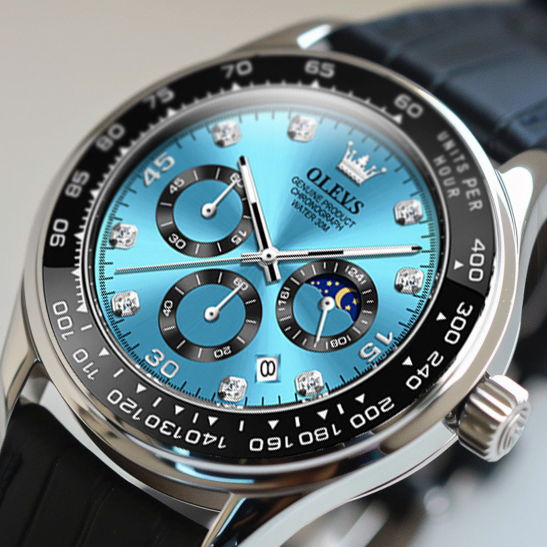 Close up, angled view of a men's Elysium Timepiece watch with a blue dial, silver case, and black leather strap, highlighting the intricate dial details. The watch features a chronograph, date display, and luminous hands.