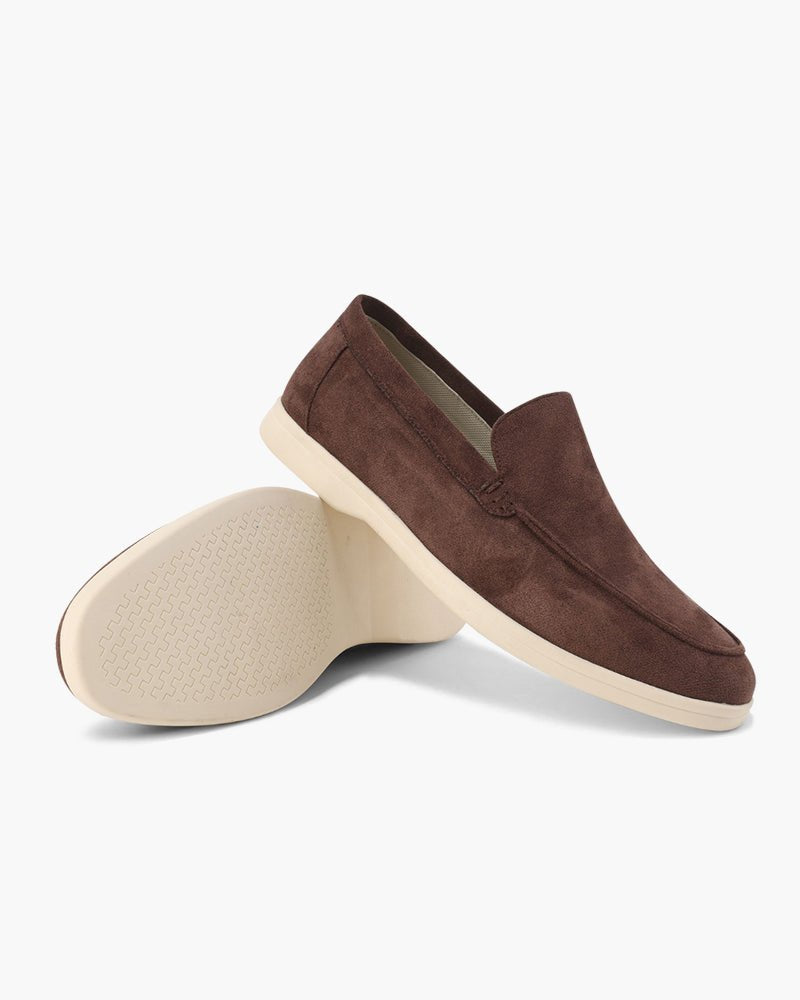 Heritage Luxe Suede Loafers with Classic Stitching in Chocolate brown, shown from a side view with one loafer upright and the other on its side revealing the textured cream sole.