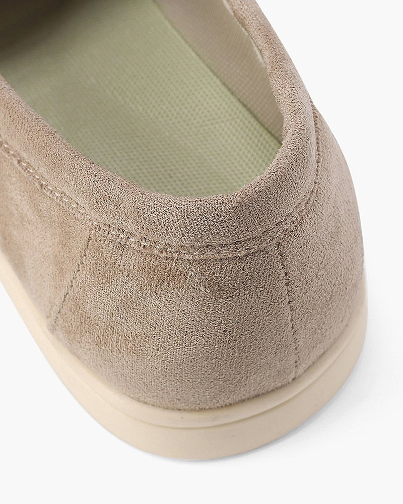 A close-up view of the heel of a Heritage Luxe beige suede loafer, showcasing the back stitching and the light green inner lining.