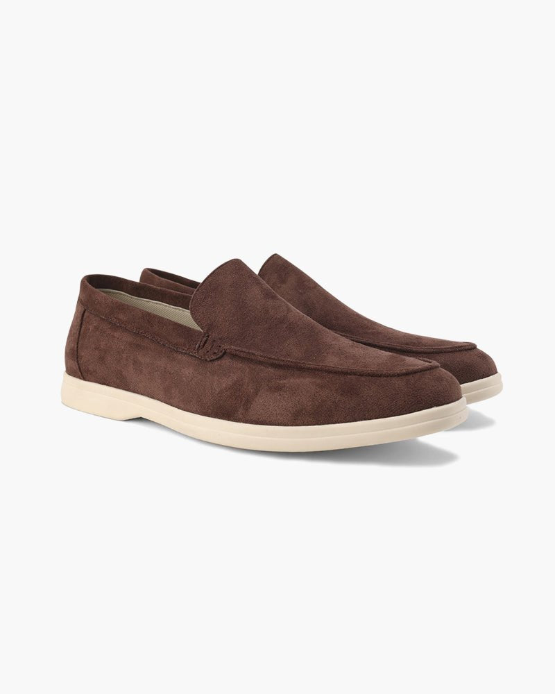 A pair of chocolate brown Heritage Luxe suede loafers with classic stitching and white soles, presented in a side view on a clean white background.