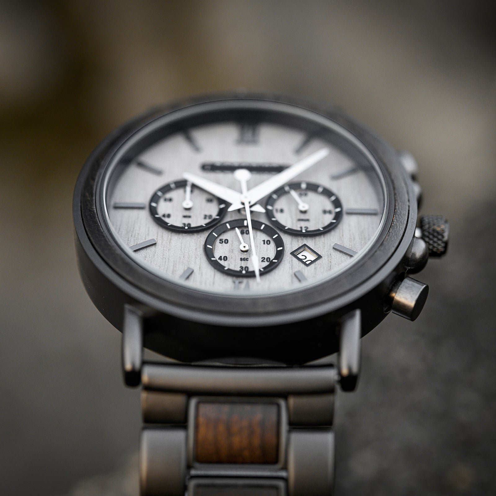Detailed close-up of the Heritage Oak men's watch face, featuring a grey dial, three subdials, white hands, and a date window.