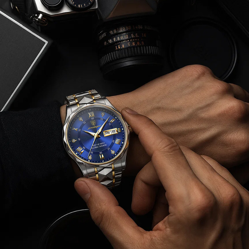 Maverick Luxe men's watch in stainless steel gold two-tone with blue dial, date display, and luminous hands, being adjusted on a man's wrist, with a camera lens in the background.