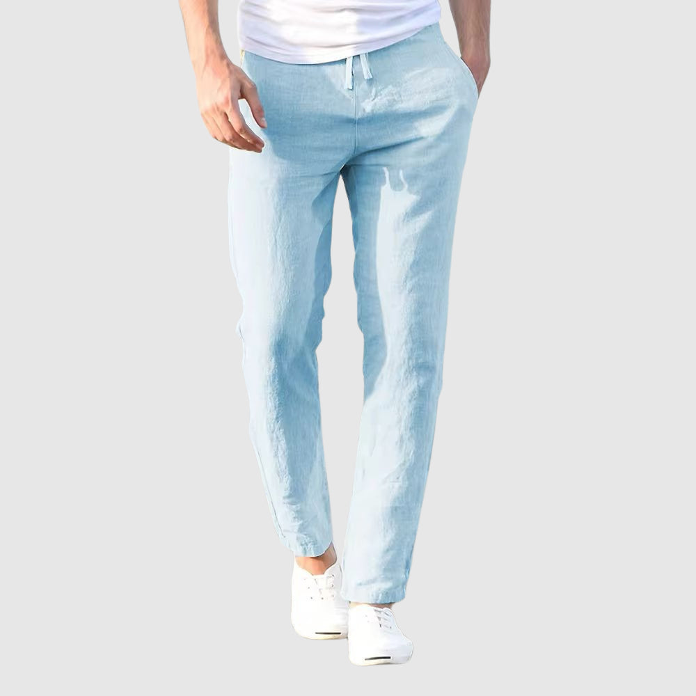 Seaside Retreat men's blue linen pants with relaxed fit, modeled with a white t-shirt and white sneakers. Lightweight and breathable fabric for summer fashion.