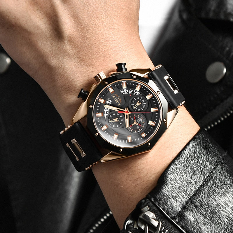 Close-up of a man's wrist wearing the Skyline Aviator men's quartz watch. The watch features a bold gold case, black dial with luminous hands, chronograph subdials, and a black silicone strap. The man is wearing a black leather jacket.