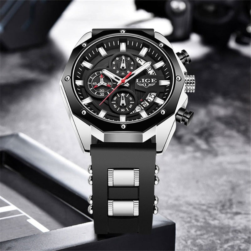 Close-up of the Skyline Aviator men's quartz watch, featuring a silver case, black dial with luminous hands, chronograph subdials, and a black silicone strap with silver accents, against a blurred background.