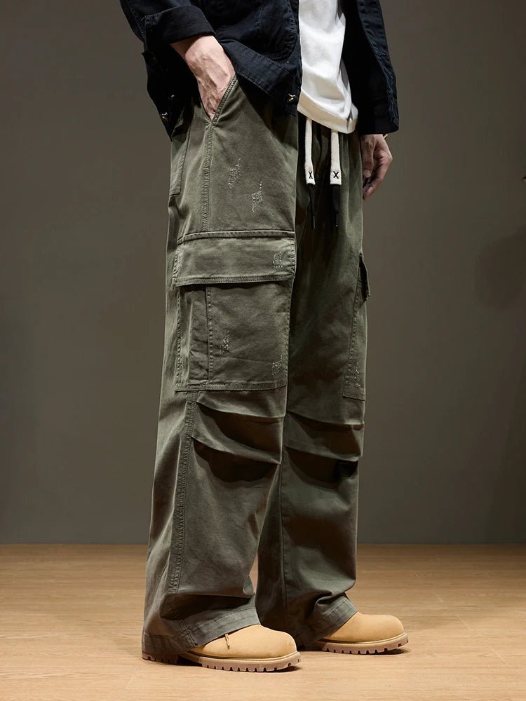 Summit Trail Cargo Pants in green, modeled by a man from a side angle, highlighting the comfortable drawstring waist, spacious cargo pockets, and durable fabric. Perfect for men's outdoor adventures.