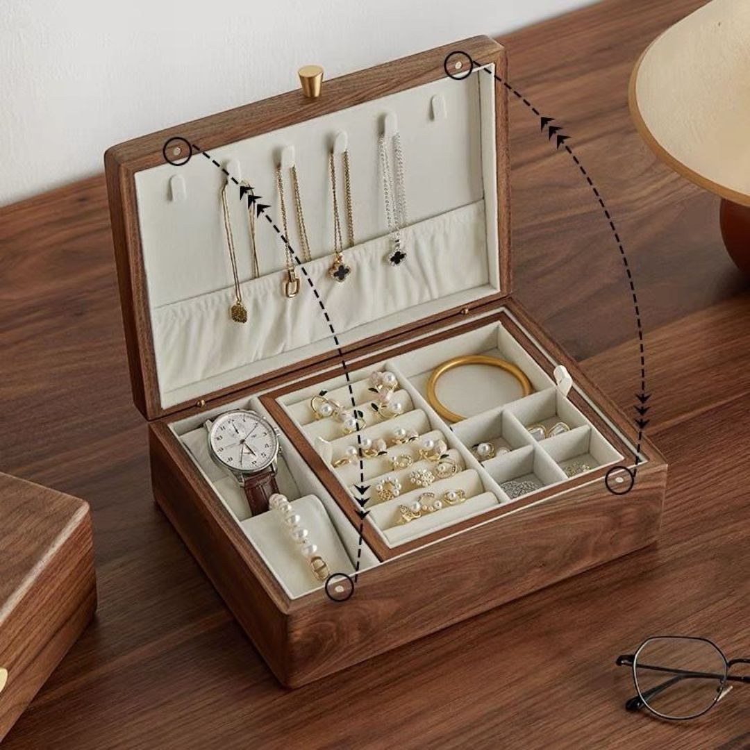 An open Timber Haven solid walnut wood jewelry box with a removable tray, displaying watches, rings, earrings, and necklaces. Graphic overlays with dotted lines and circles highlight product features on a wooden desk.