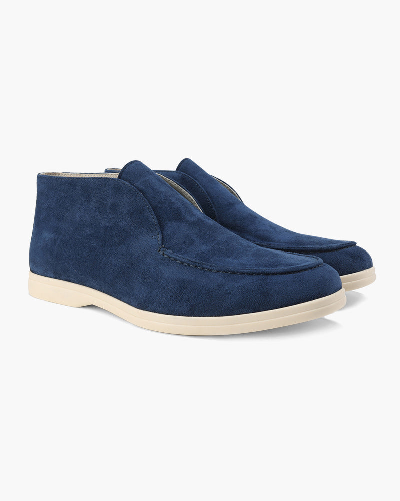 A pair of marine blue suede loafers with classic detailing, featuring a mid-cut design, presented on a clean white background.