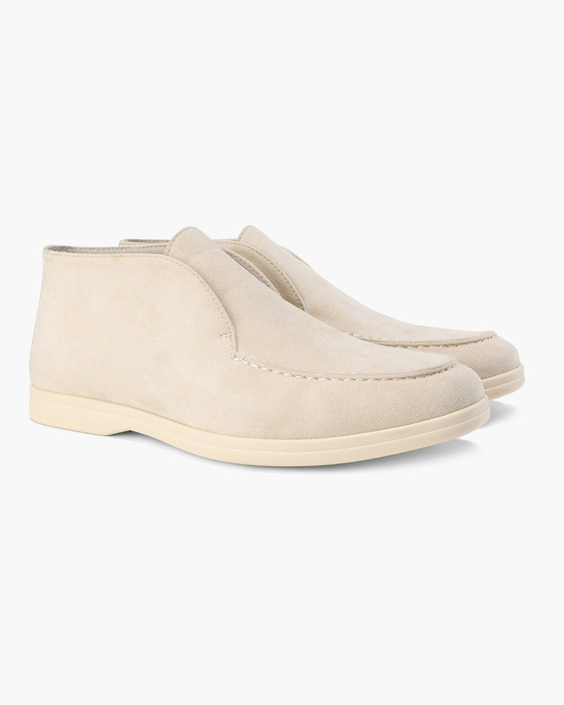 Pair of beige suede loafers with classic detailing, mid-cut style, on a white background.