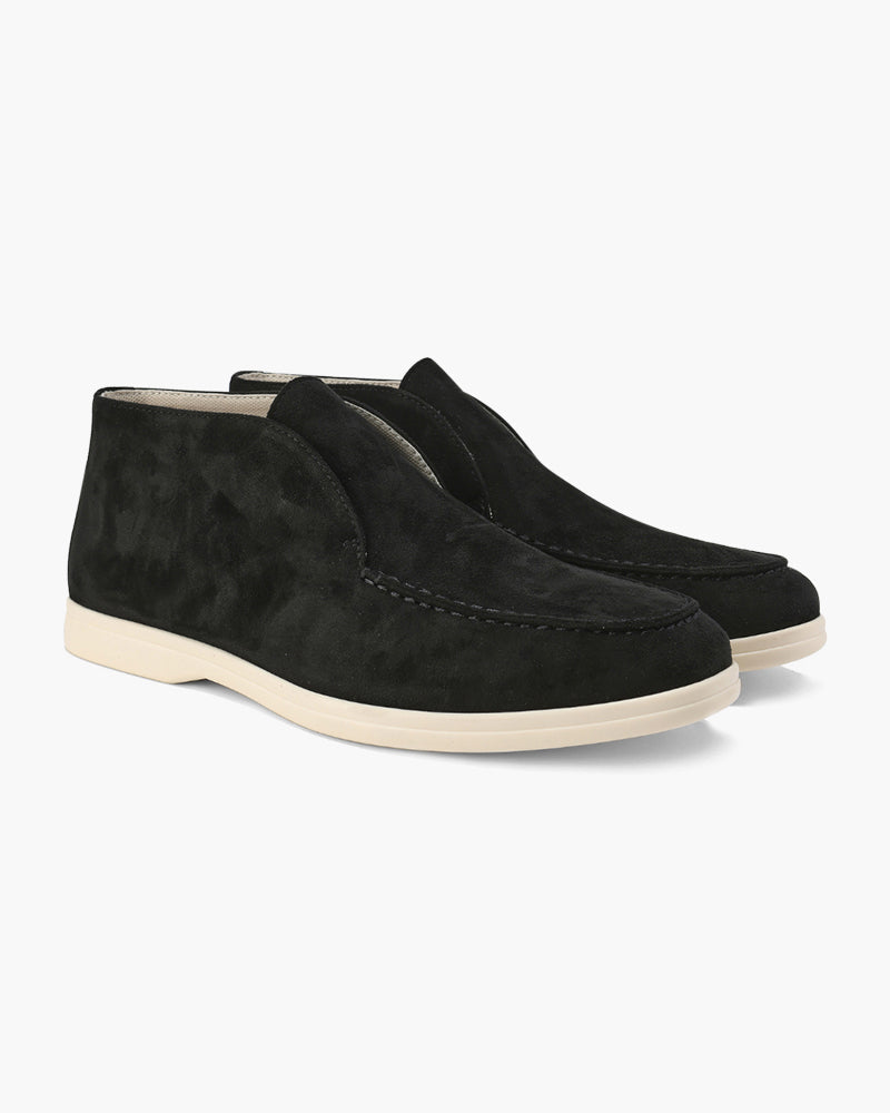 Pair of black suede loafers with classic detailing and light soles, presented on a white background.