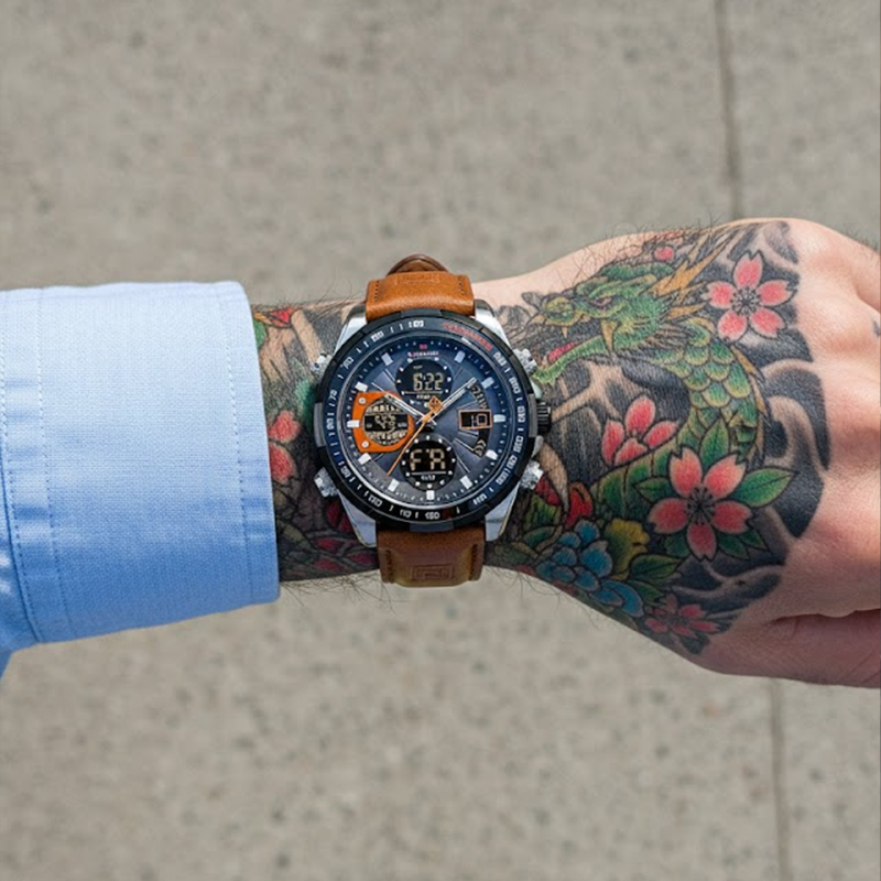 Aether Voyage men's quartz watch with a brown leather band and gray dial, worn on a man's tattooed arm, showcasing the watch in a lifestyle setting.