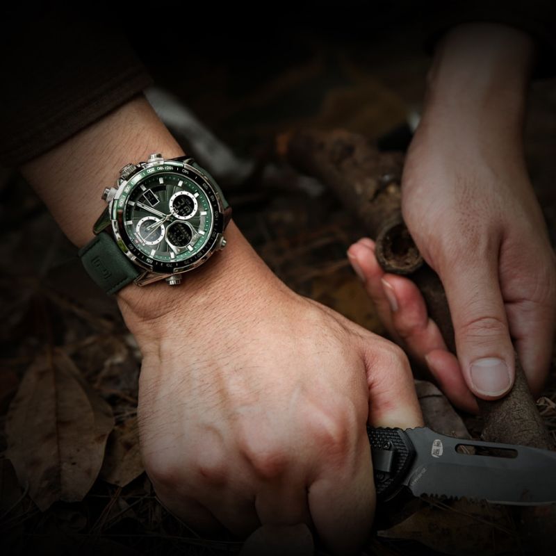 Aether Voyage Men's Quartz Watch with a green leather band and green dial, worn on a man's wrist, holding a black folding knife in a natural, dark outdoor setting.