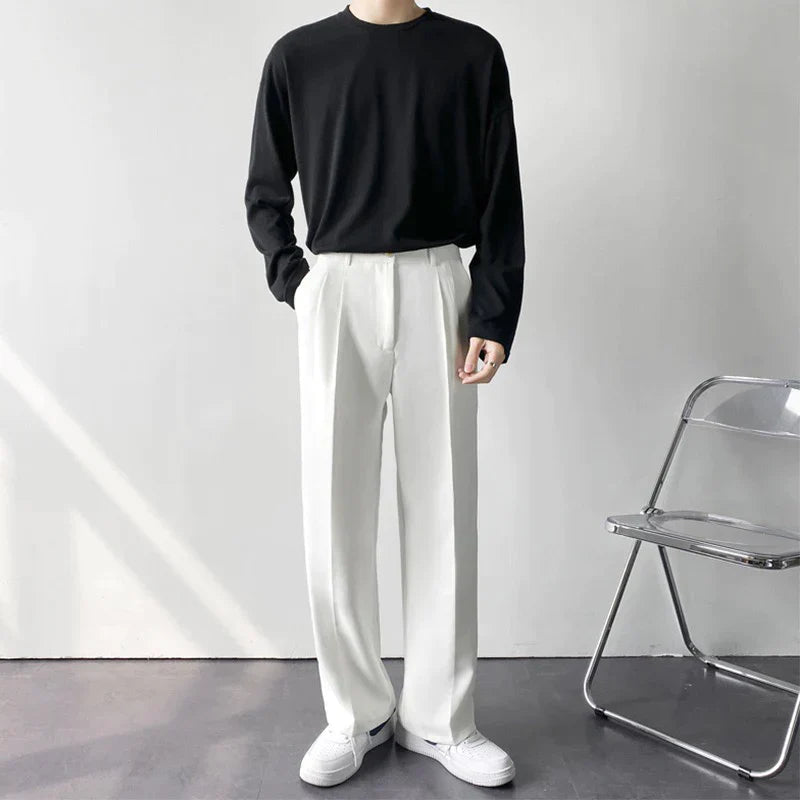 Men's Arno Trousers in white linen, tailored fit, styled with a black long-sleeve shirt. Ideal for versatile summer fashion.
