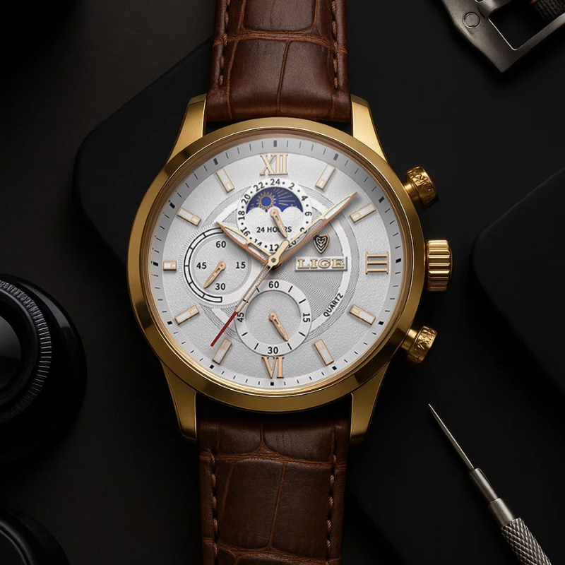 Aurelius Timepiece men's watch with gold case, white dial, and brown crocodile-patterned leather strap, featuring luminous hands and a moon phase complication, displayed on a dark surface with watch tools.