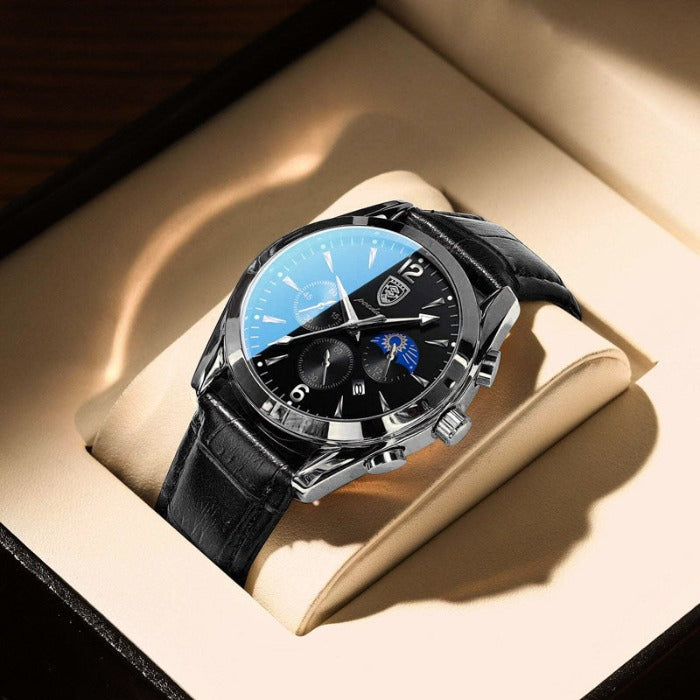 Aventadori men's watch in silver with a black leather strap and black dial, featuring chronograph sub-dials and a moon phase indicator, displayed in a brown watch box. This 'Silver Black' variant offers a sleek, modern aesthetic.