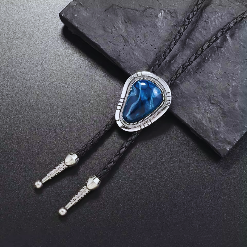 Bolo tie with blue stone and silver accents on a dark surface