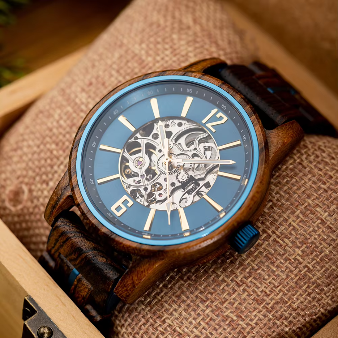 Close-up of the Cascadia Blue men's wooden watch with stainless steel accents, featuring a blue dial and skeleton movement, resting on a brown woven cushion inside a wooden box.
