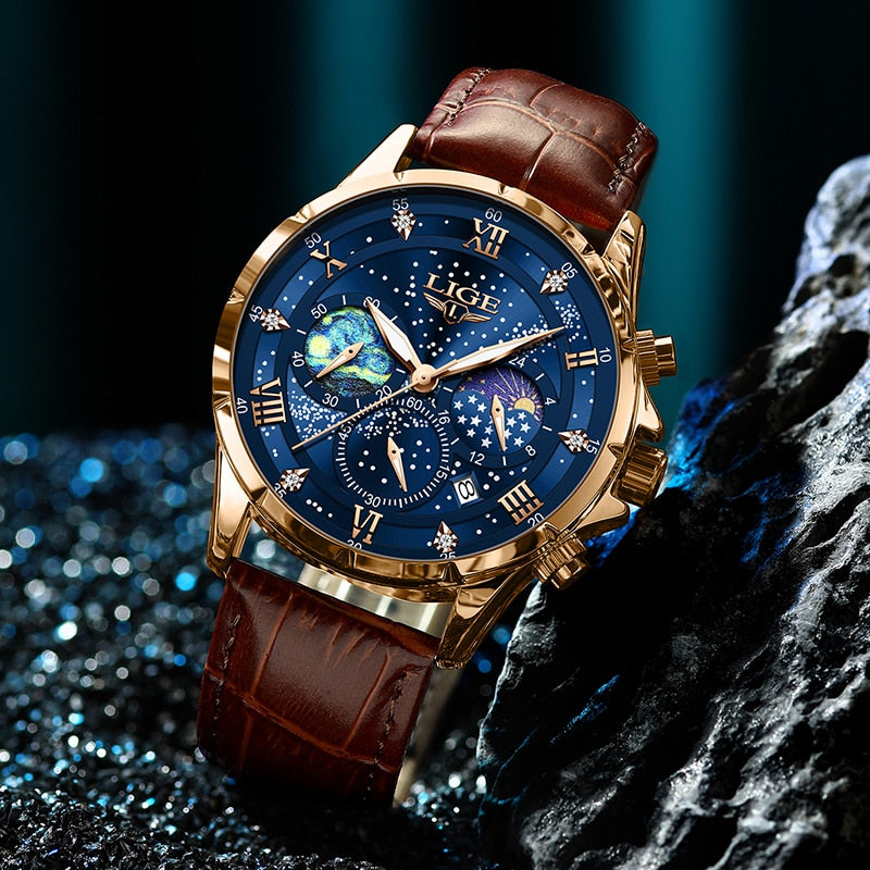 Men's Celestial Timekeeper watch in rose gold with a blue starry chronograph dial and brown leather strap, resting on a dark, sparkling textured surface.