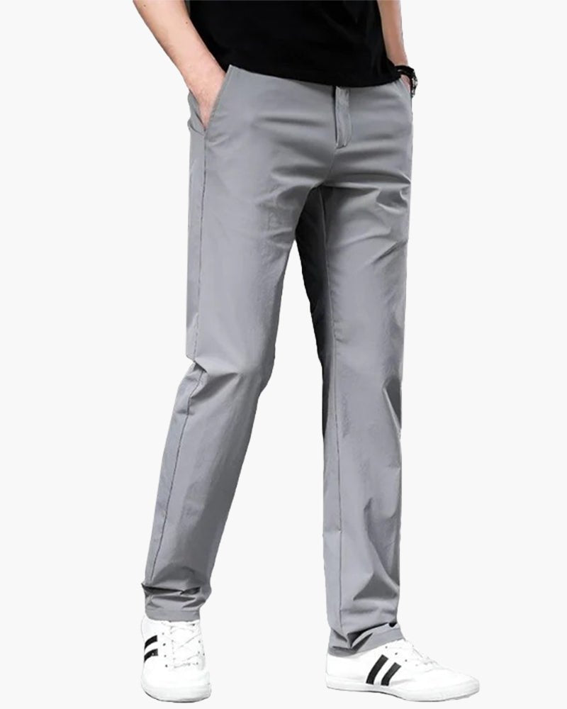 Men's Cielo Vento gray casual trousers in lightweight cotton, shown on a model in an angled pose with hands in pockets, highlighting the relaxed fit. Paired with a black t-shirt and white sneakers.