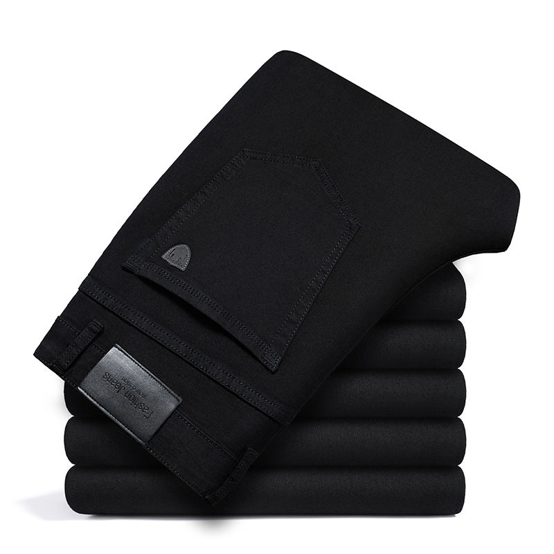 Stack of five folded Cityscape Trousers men's premium cotton classic fit pants in black, showing the back pocket and brand label.