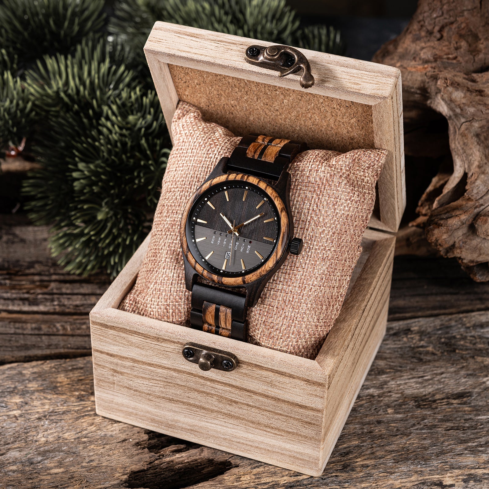 Eclipse Noir men's watch, black stainless steel case, minimalist dial, and two-tone dark and light wood strap, displayed open in a light wooden box with a fabric cushion.