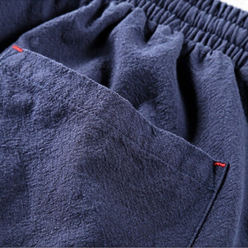 Detailed close-up of the elastic waistband and side pocket of the Edo Escape Japan-style linen trouser in blue, showcasing the lightweight fabric texture and a small red stitch detail.