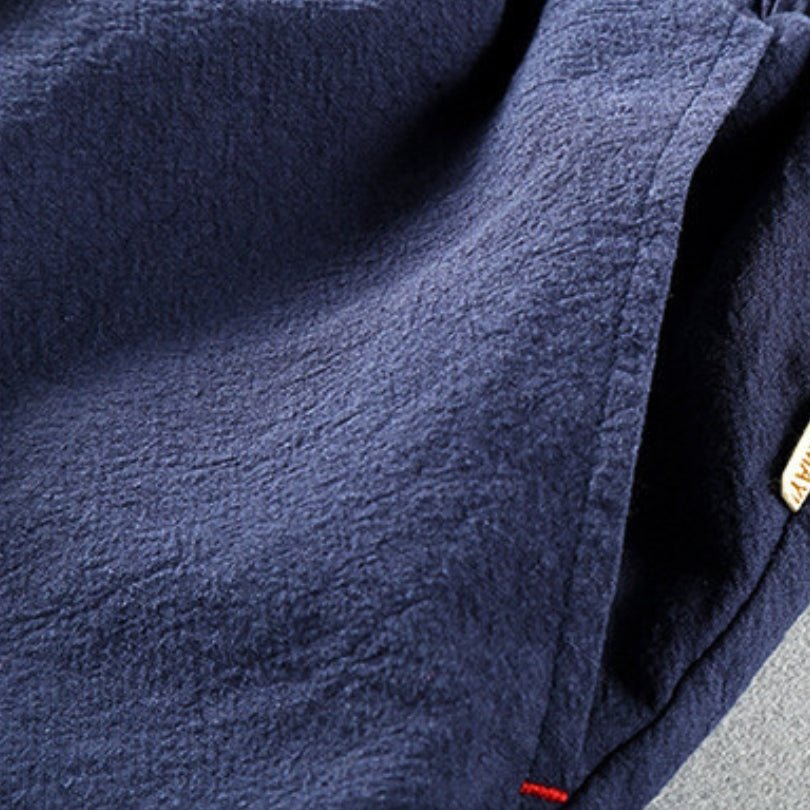 Close-up view of the lightweight linen fabric texture and side pocket detail of the Edo Escape Japan-style trouser in blue, featuring a subtle red stitch accent. Highlights the breathable material and relaxed fit.