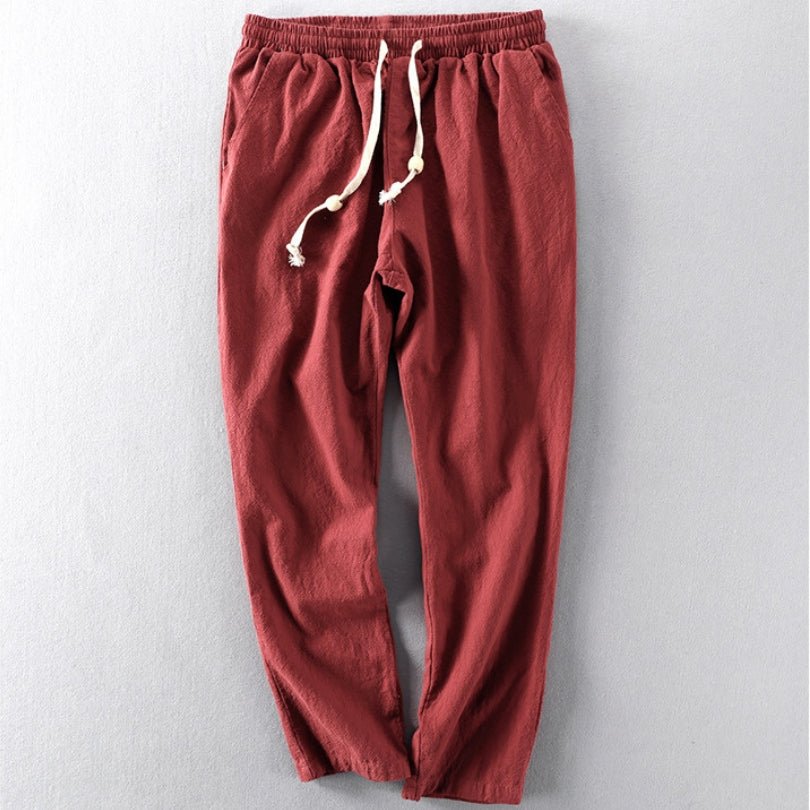 A pair of red Edo Escape Japan-style linen trousers, laid flat on a light gray background, showcasing a relaxed fit, elastic waistband, and a contrasting cream-colored drawstring.