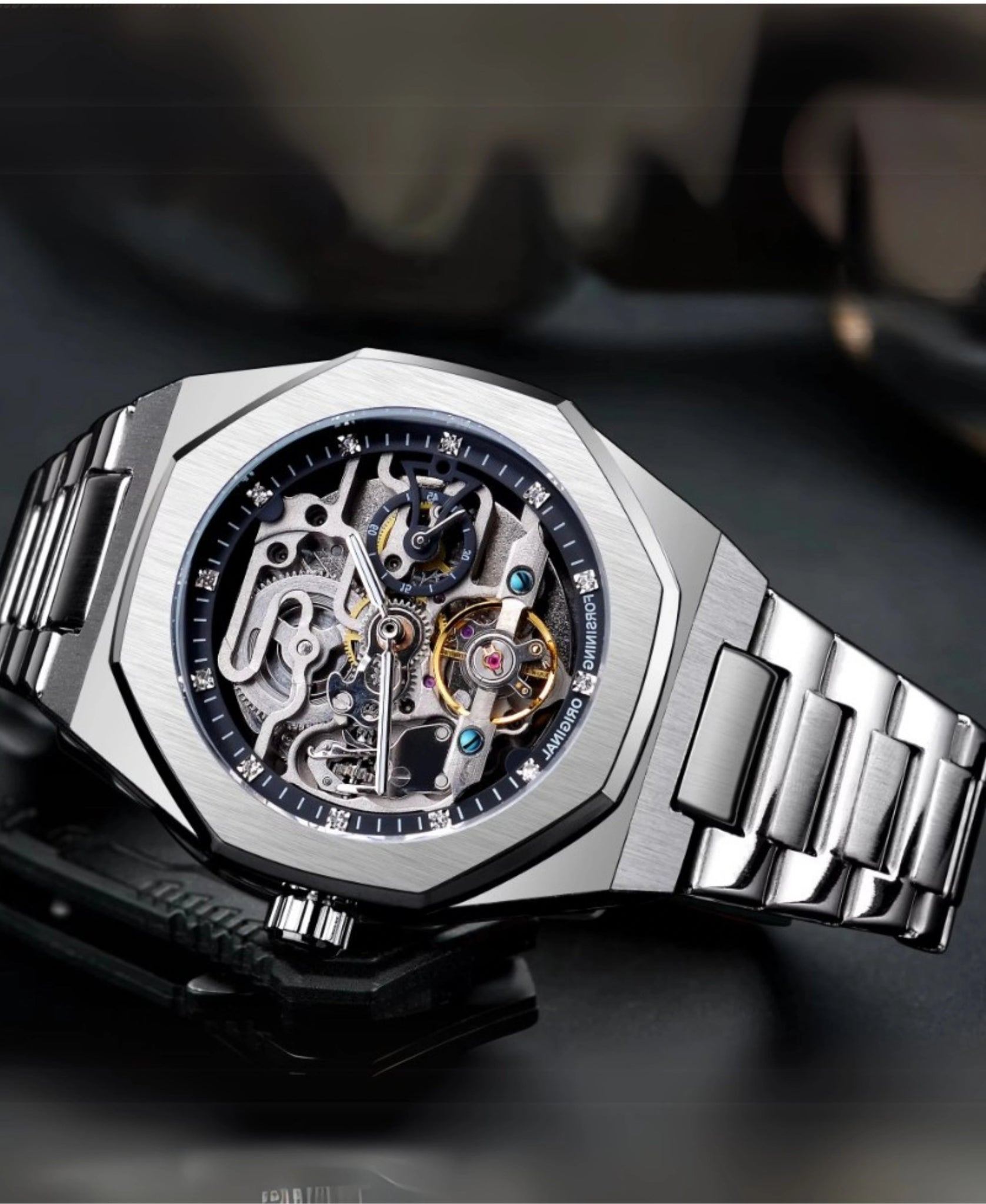 Angled perspective of the Eidolon Skeleton Art Sculpture in silver, resting on a dark surface, emphasizing its detailed internal gears and overall modern design.