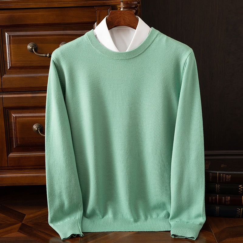 Green cashmere sweater with a white collar on a wooden hanger, showcasing its fresh color and soft, high-quality fabric. An elegant and cozy pullover.
