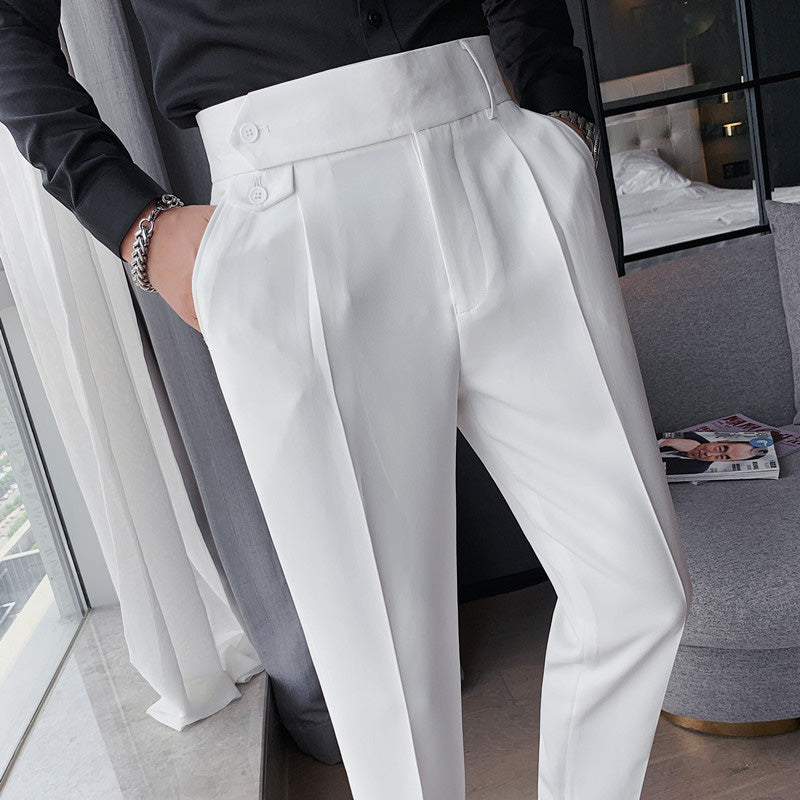 A man wearing white Elysian high-waisted slim-fit trousers in premium fabric, with his hands in the pockets, paired with a black shirt.