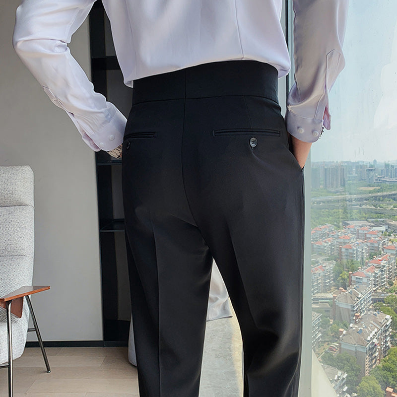 Back view of a man wearing Elysian high-waisted slim-fit trousers in black, paired with a white shirt. The image emphasizes the tailored finish and the design of the rear pockets.