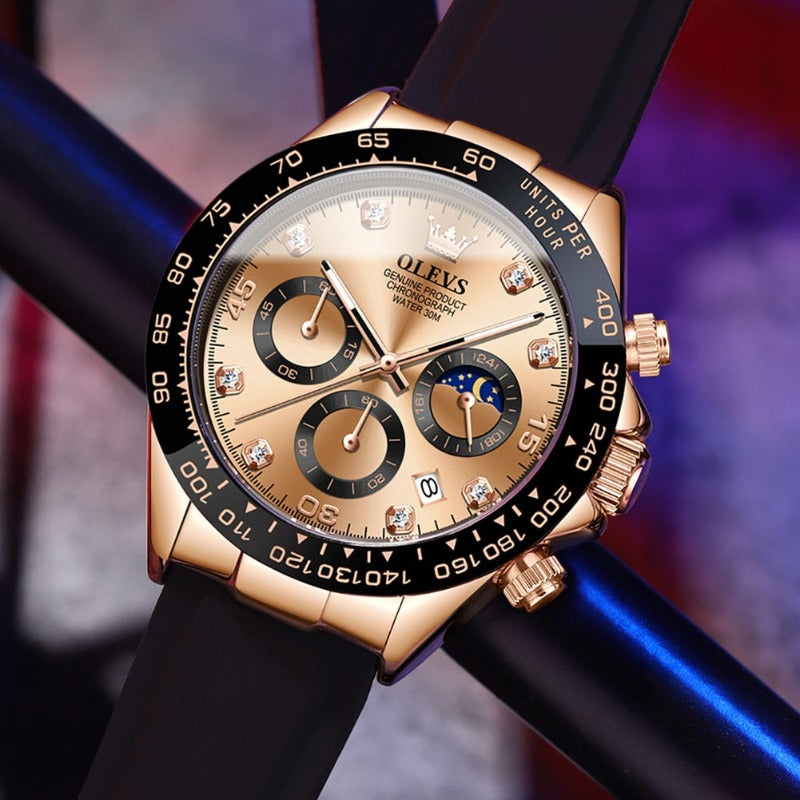 Overhead view of a men's Elysium Timepiece watch with a champagne dial, rose gold-tone case, black silicone strap, quartz movement, and luminous hands, on a dark background. Features three subdials and diamond-like hour markers.