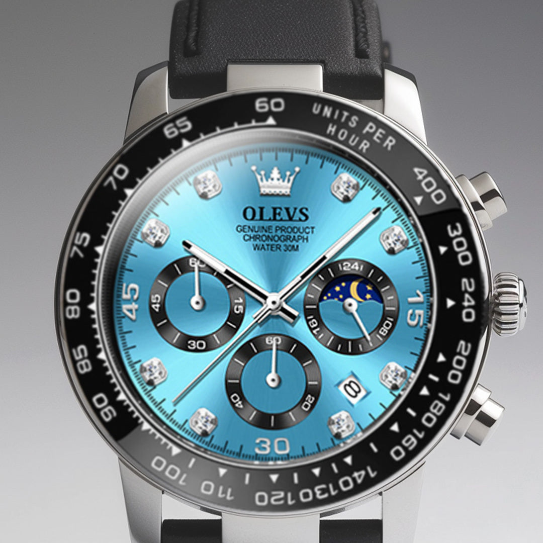Close up of a men's Elysium Timepiece watch with a blue dial, silver case, and black silicone strap. The watch features a chronograph, date display, and luminous hands.