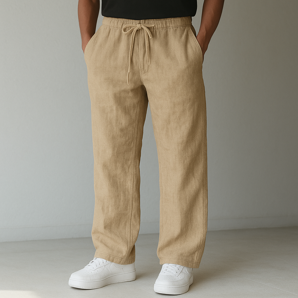 A person models khaki Elysian Breeze linen pants with a relaxed fit, featuring a drawstring waist, paired with white sneakers against a minimalist background.