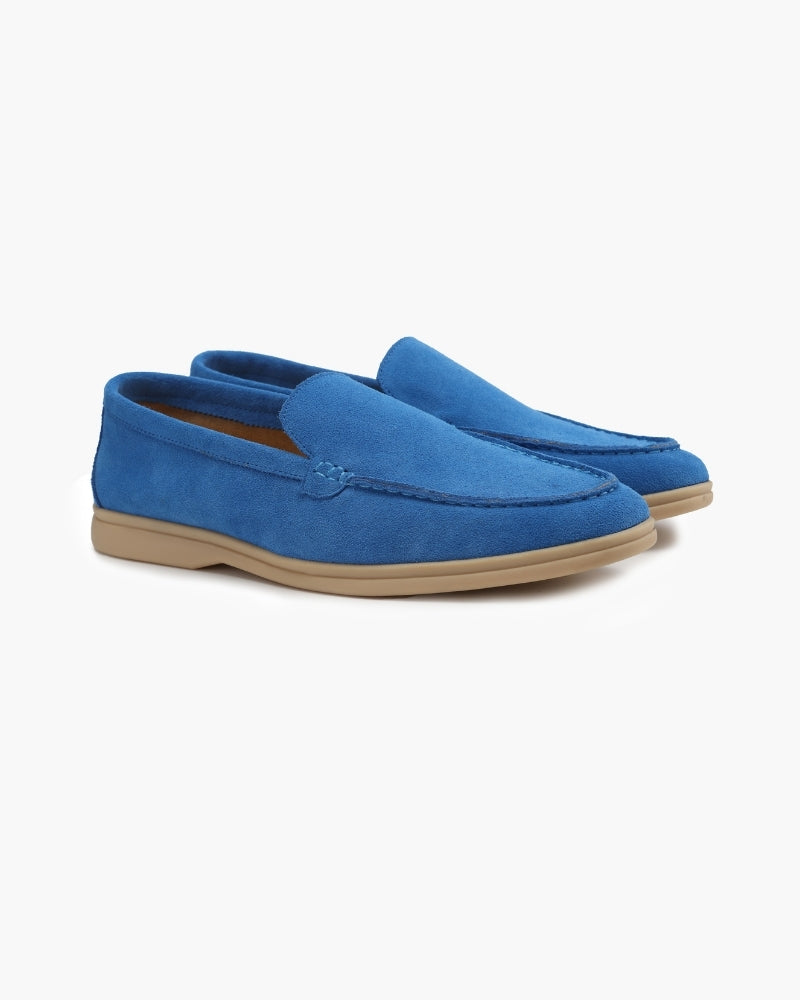Heritage Luxe men's blue suede loafers with classic stitching light beige soles, shown as a pair from an angled front view on a white background.