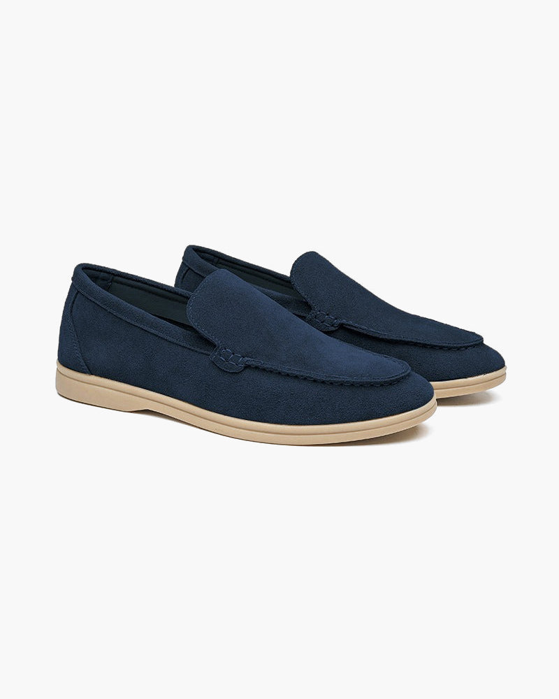 Heritage Luxe men's marine blue suede loafers with classic stitching, shown as a pair from an angle on a white background. Timeless design for casual or dressy style.