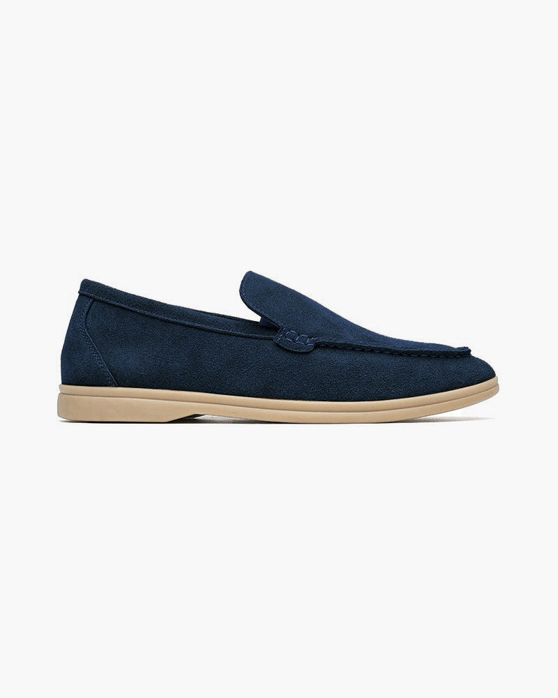 Heritage Luxe men's navy blue suede loafer with classic stitching a light beige sole, shown from a side profile on a white background.