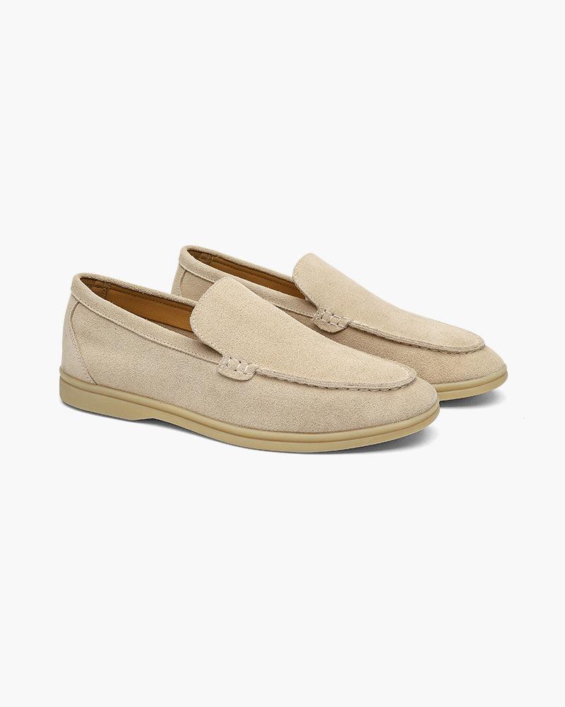 A pair of Heritage Luxe men's beige suede loafers with classic stitching, displayed on a clean white background. The comfortable, timeless design is suitable for casual or dressy styles.