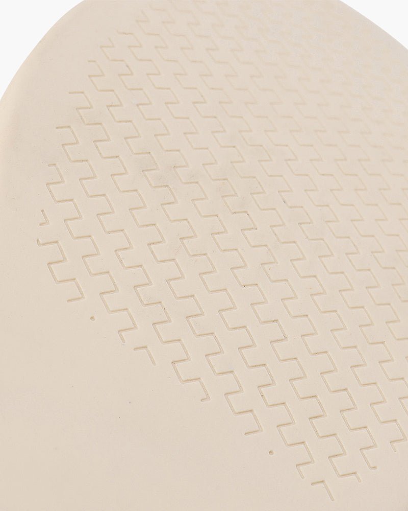 A close-up view of the beige sole of a Heritage Luxe loafer, featuring a repeating zigzag textured pattern for grip.