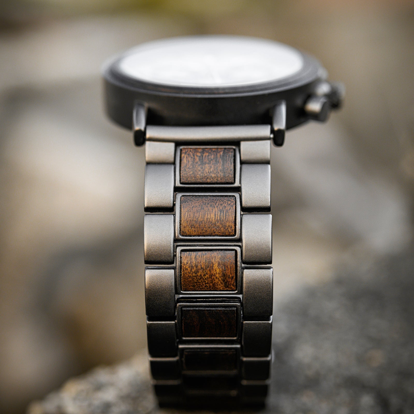 Close-up view of the Heritage Oak men's watch band, showcasing the dark metal links and natural wood inserts.