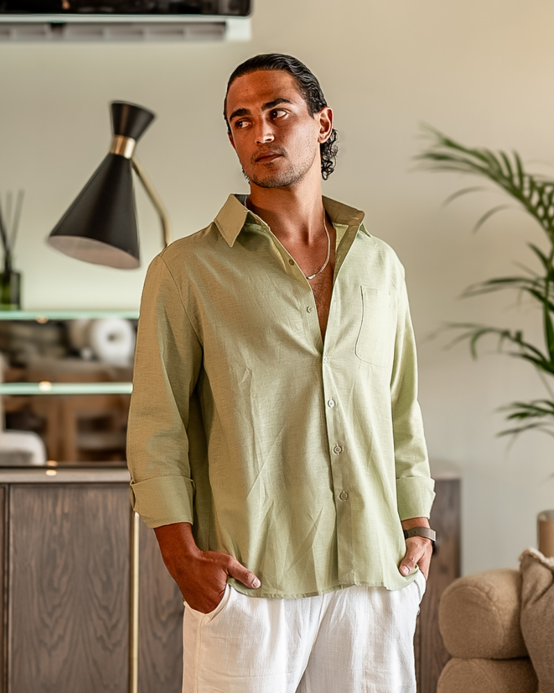 Male model wearing a Mint Green Linen Essence men's shirt with a classic fit, sleeves rolled up, paired with white linen pants. Showcases the breathable fabric and versatile style for casual wear.