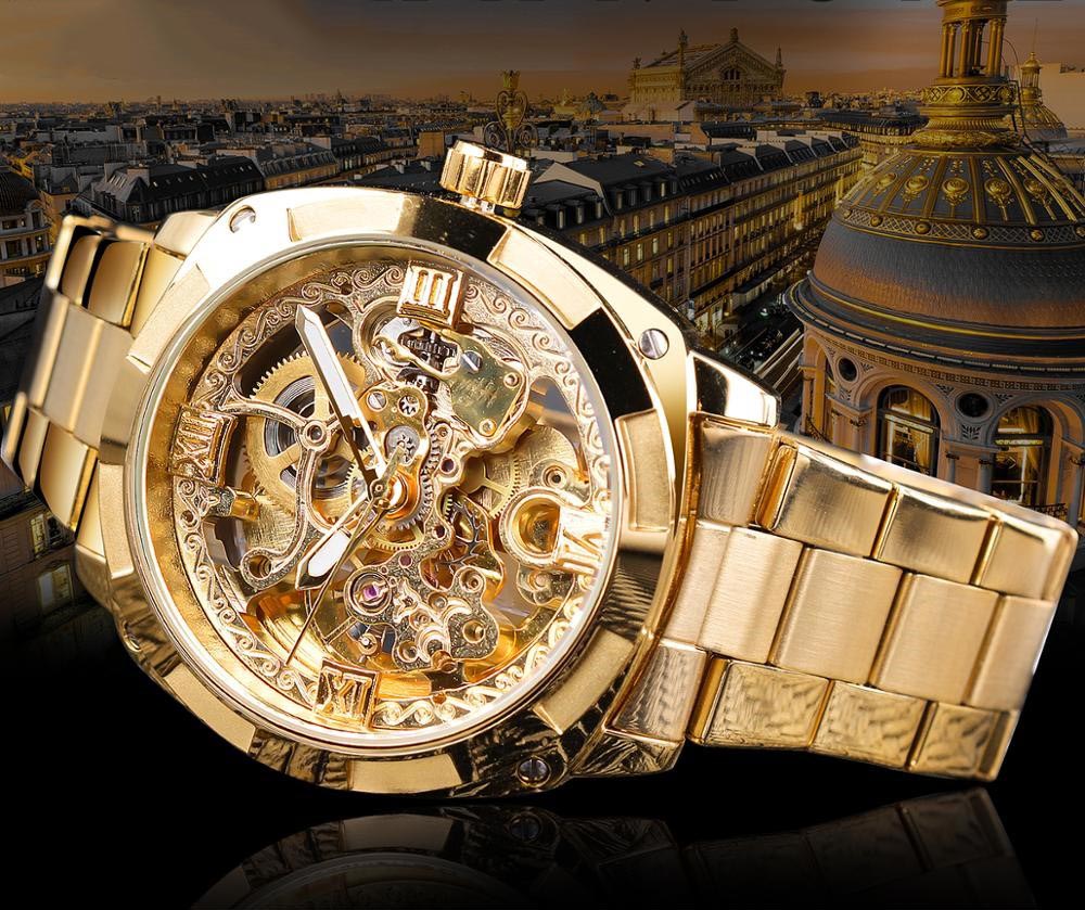 A close-up view of the Luxe Aura Men's Analog Watch in gold, featuring a skeleton dial that reveals intricate mechanical gears. The watch has luminous hands and a stainless steel band, set against a blurred cityscape background.
