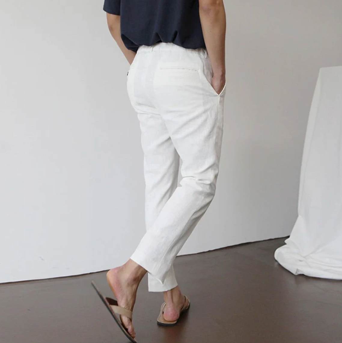 Luxe Harbor white linen trousers with a tailored fit, shown on a male model from the back side. Highlights the comfortable fit casual style these breathable summer pants.
