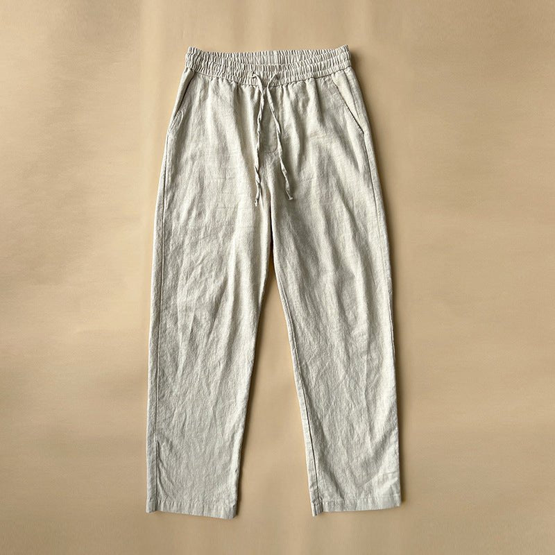 A single pair of khaki Luxe Retreat Comfy Linen Pants with Relaxed Fit, featuring an elastic drawstring waist and side pockets, laid flat on a neutral brown background.
