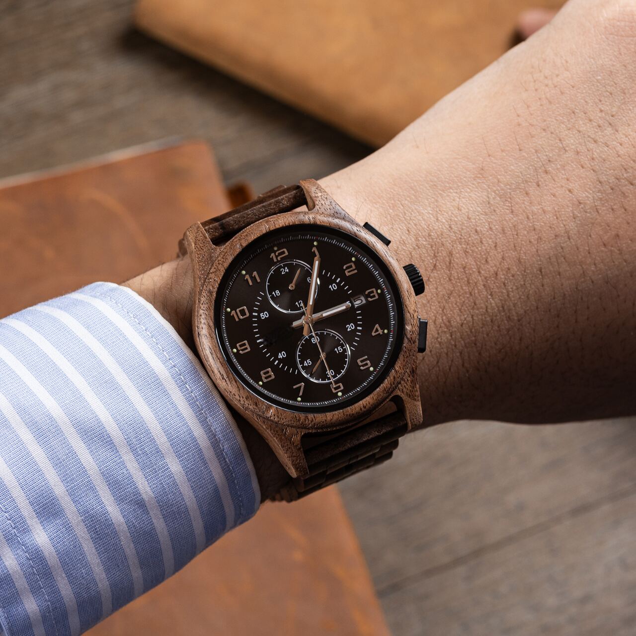 Regal Oak men's watch with walnut finish silver accents on a man's wrist, wearing a striped blue shirt.