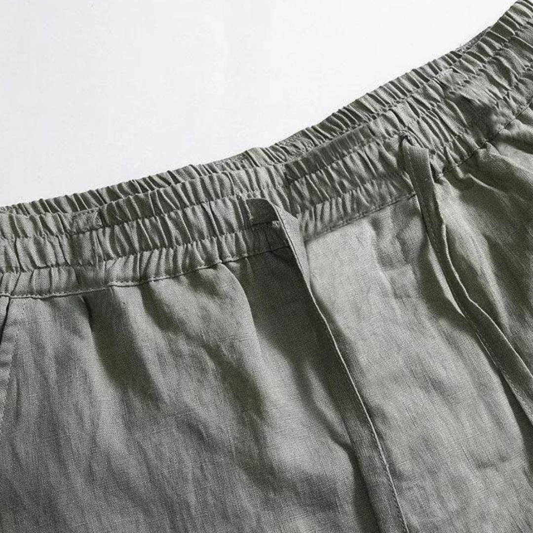 Close-up of Sahara Whisper green linen pants waistband, showing elastic drawstring detail. Highlights soft touch fabric comfortable design.